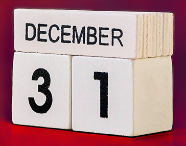 31 December wooden cube calendar on wood surface red background.