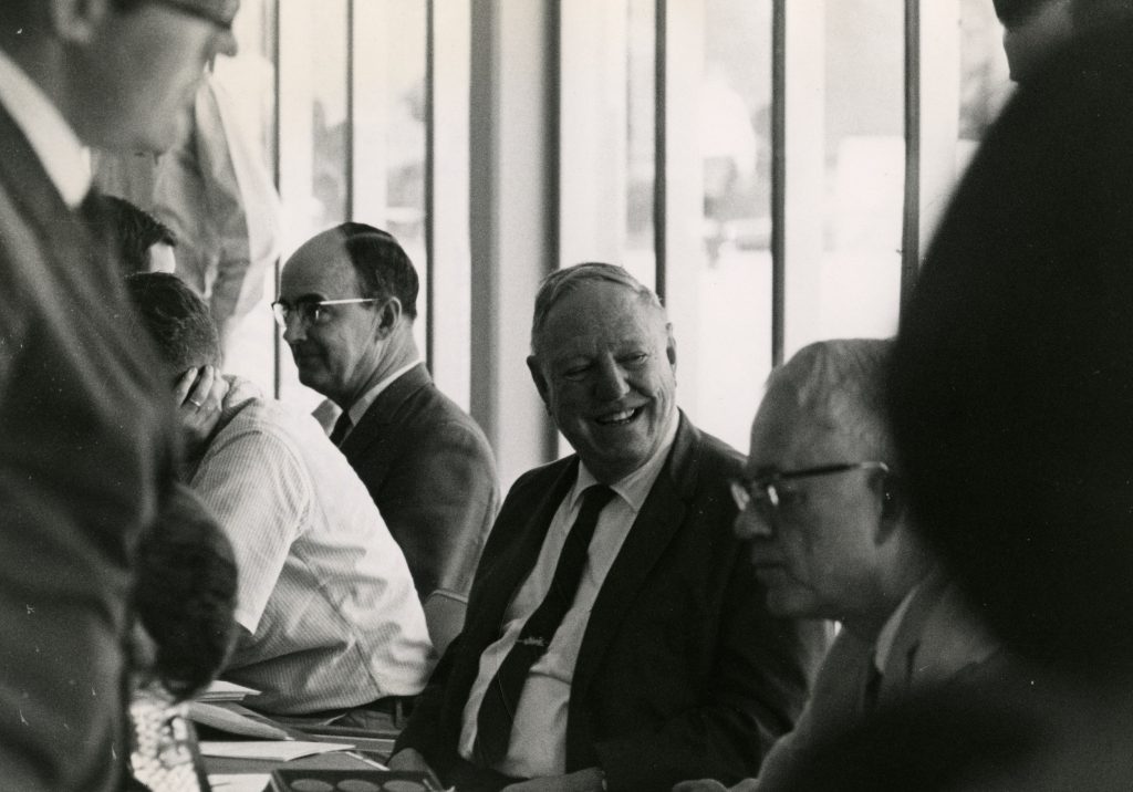 Black-and-white photograph of Irvine W. Grote (center) and unidentified individuals. 