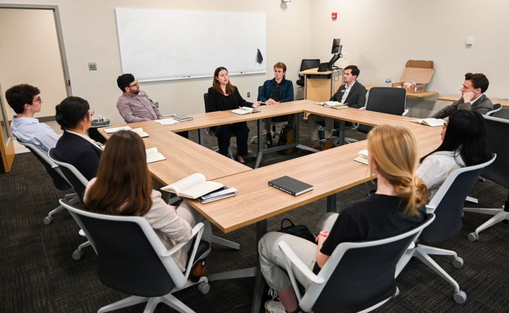 Stock photo of a group of people sitting around a conference table. 