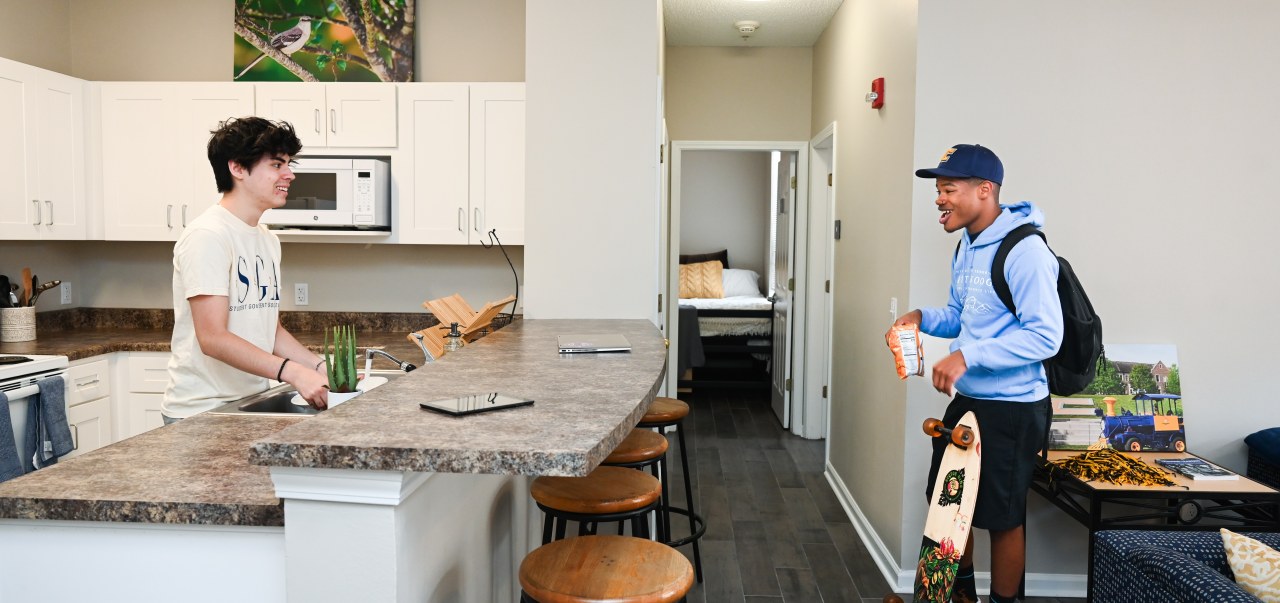 Two students engage in a conversation in the residence hall. 