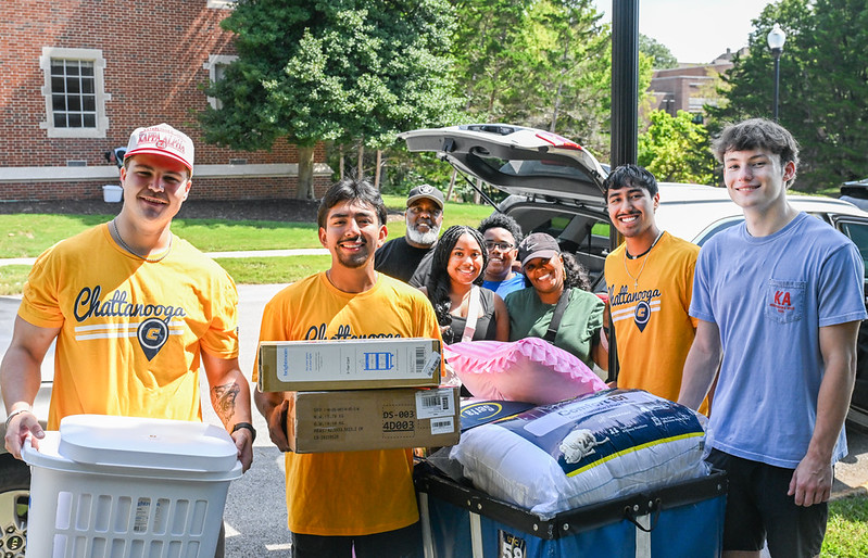 Students and campus volunteers smile for a photo during move-in