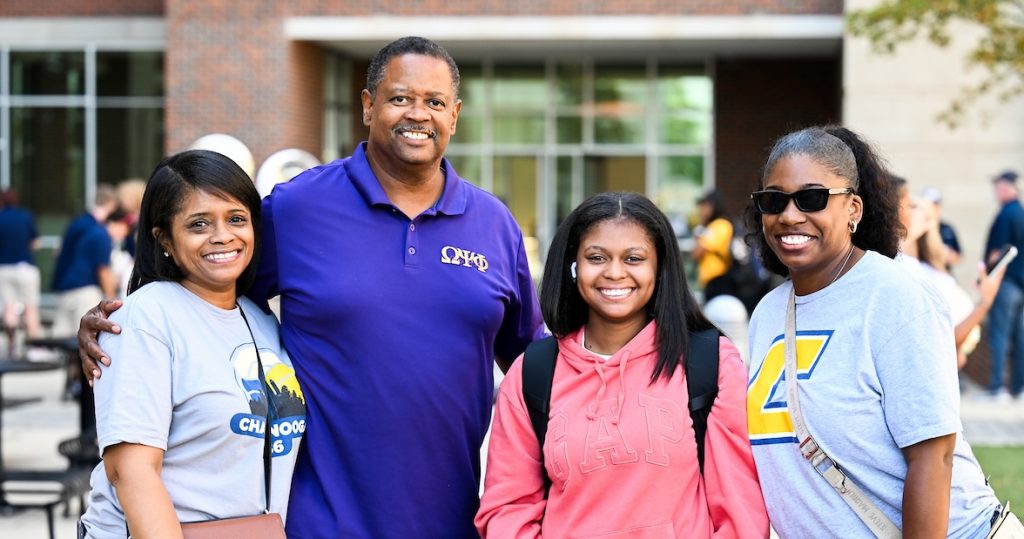 A student and her family pose on Move-In Day