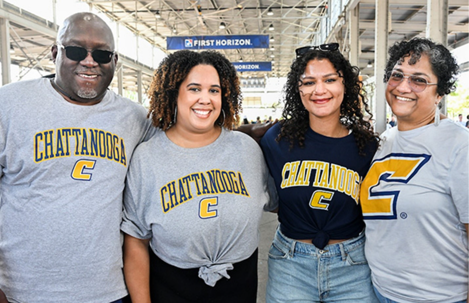 Four Chattanooga fans gather to smile for a photo in the First Horizon Pavillion