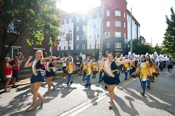 The marching mocs walk down vine street in the homecoming day parade