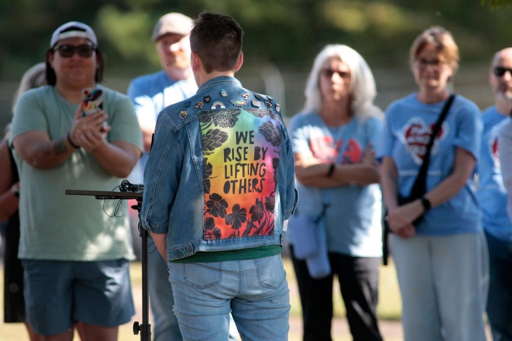 Elizabeth Haley, executive director of Seed Theater, addressing the press, supporting queer kids' mental health in Hamilton County Schools, September 2025. The back of her jacket says we rise by lifting others. Photo Credit: Seed Theater