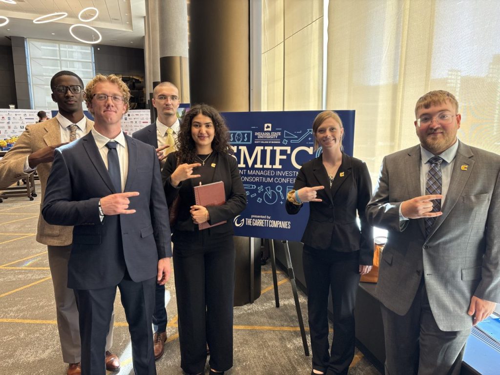 Students post next to SMIFC welcome sign