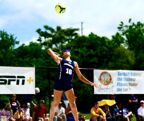 Julia Lawrence spikes the volleyball during a UTC beach volleyball match.