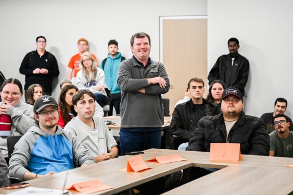 Ryan Russell stands in classroom with students looking at screen