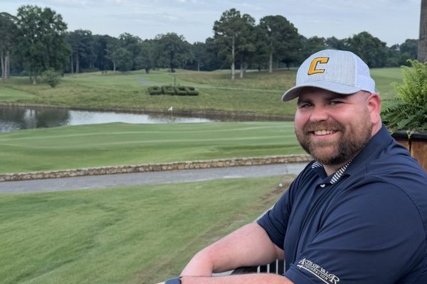 Kevin Rhodes wearing a UTC hat overlooking golf course.