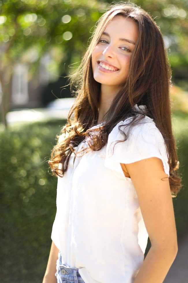 Reagan Macey poses for a photo, smiling in the sun. 