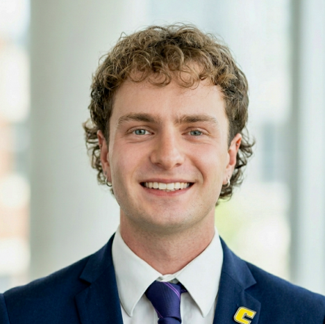 Man smiling while standing in a corporate office