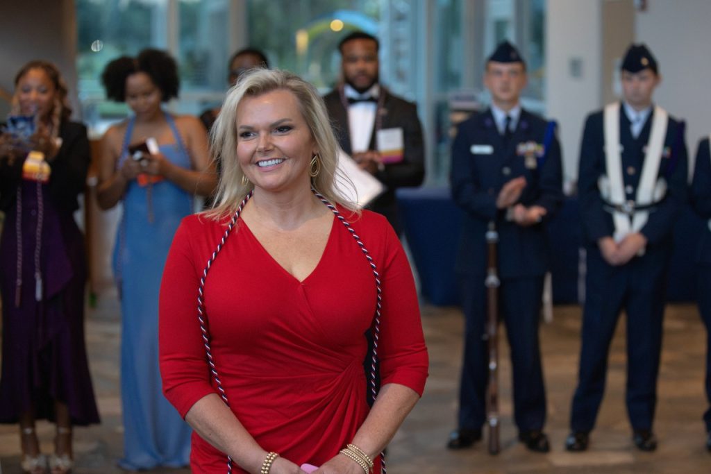 Woman wearing red dress smiles as she walks