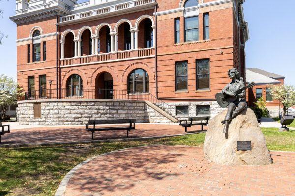 The courthouse building in Sevierville, TN is shown with a statue of Dolly Parton out front.