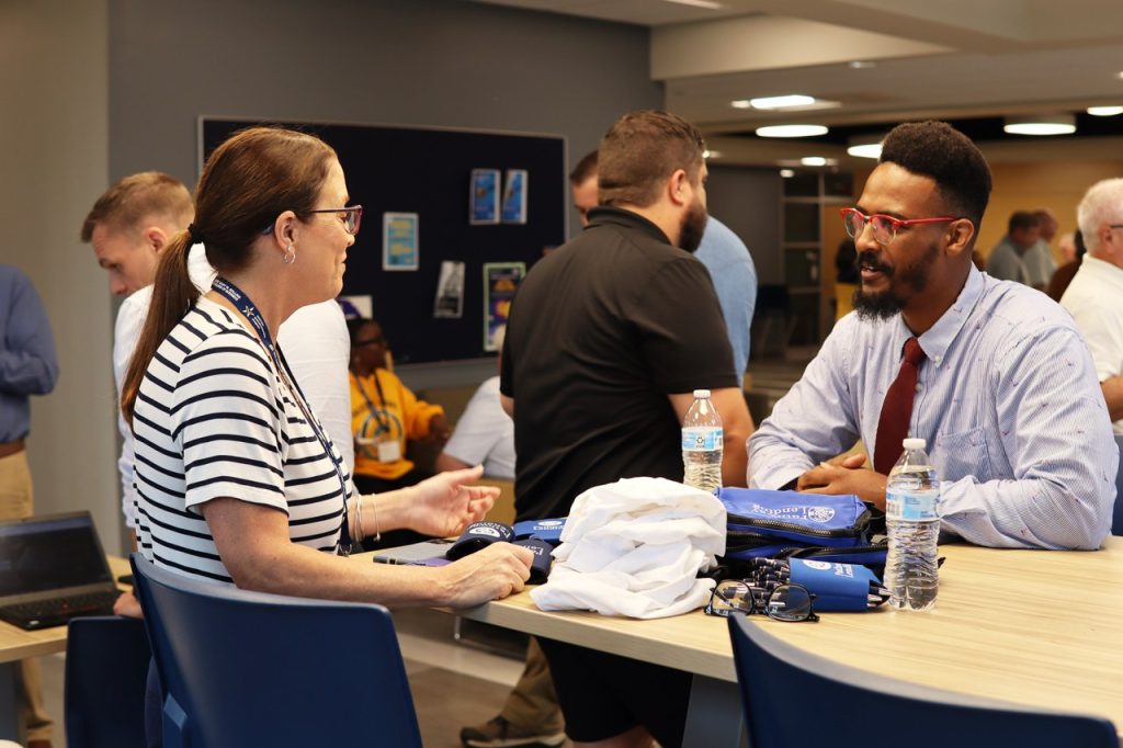 Man and woman wearing business clothes talking across a table