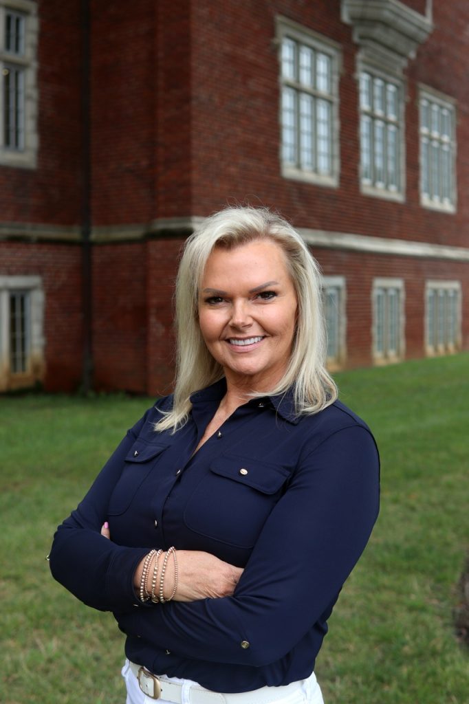 Woman wearing blue shirt smiling at camera