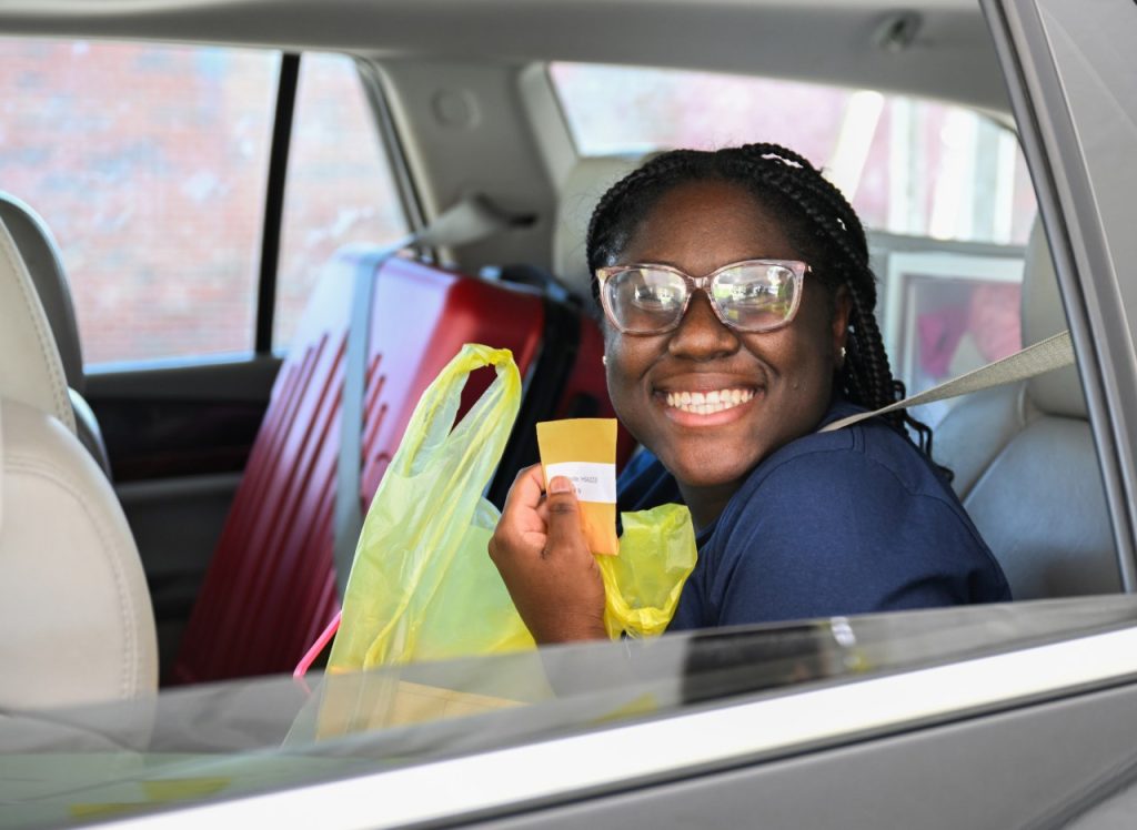 Woman smiles in car holding her apartment key
