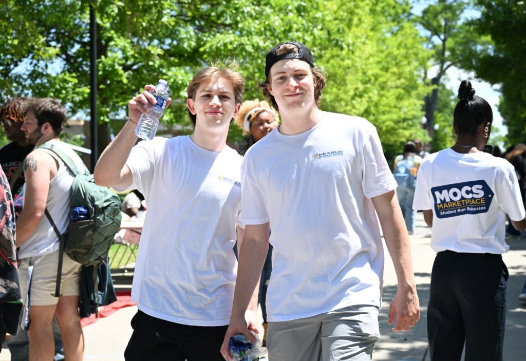 Two male students smile at the camera during Mocs Marketplace.