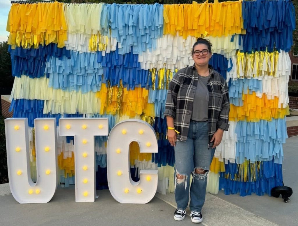 Maia Pentecost in front of a UTC sign on campus.