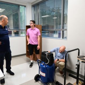 Dr. Erkan Kaplanoglu, left, mechatronics major Austin McDade and Dr. Max Jordon demonstrate a pneumatically powered balance board.