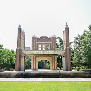 Chamberlain Pavilion on UTC’s campus, a brick open-air structure with tall columns, arches, and broad steps framed by trees and lawn.