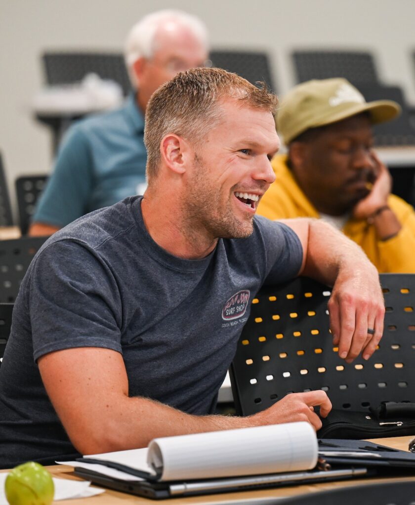 A military veteran engages in a discussion during a business course. Returning to school to earn an advanced degree can benefit many military veterans.