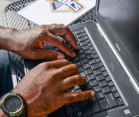 Close up of a pair of hands using a laptop computer