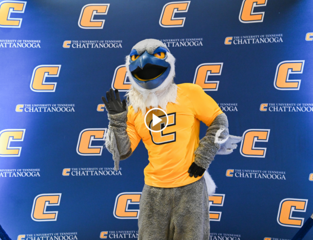 Scrappy in front of a UTC banner