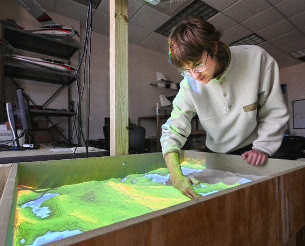 Junior electrical engineering major Nicholas Margavio demonstrates the augmented reality sandbox