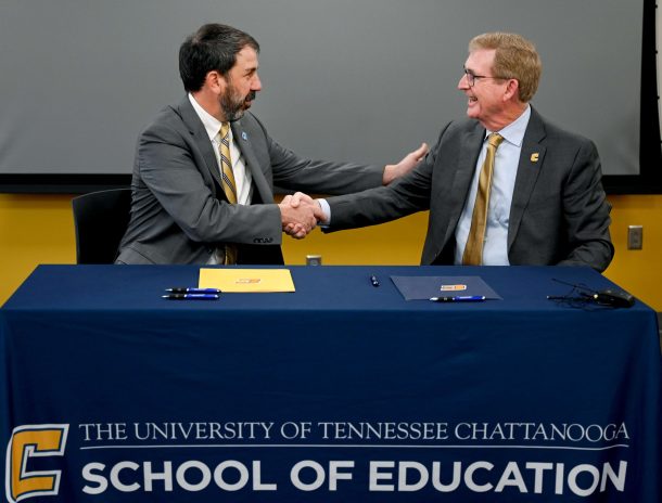Hamilton County Schools Superintendent Justin Robertson and Chancellor Angle shake hands following the signing of an MOU to extend the sponsorship of UTC’s Future Ready Institute in Teaching and Learning at Tyner Academy.