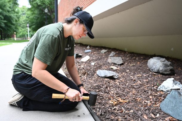 Senior environmental geology major Samantha Doss-Watson installs edging around The Rockery.