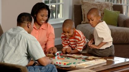 African-American family playing Monopoly together