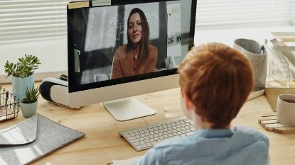 woman teaching boy through a video call