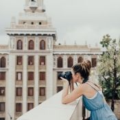 female travel photographer taking photos at a monument