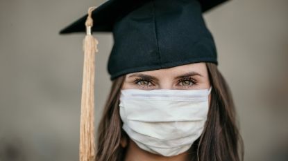 young woman wearing a graduation cap and mask