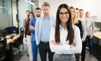 woman leader standing in front of her team in the office