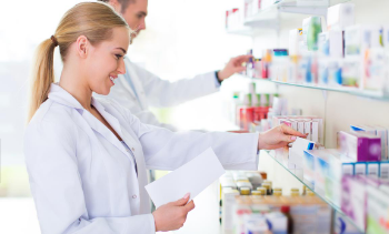female and male phamacists placing medicine on shelves