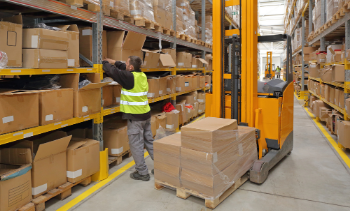 male supply chain worker loading product into shelves in warehouse