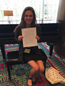 Laure holding her paper up while at CUR conference.