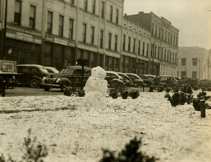 Black-and-white photograph of a snowman located in downtown Chattanooga, Tennessee. Photographed by Herman Lamb in 1945.