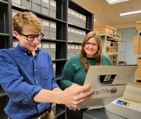 Archivists Noah Lasley and Carolyn Runyon looking at materials in the Krystal records and memorabilia collection in the Special Collections stacks.