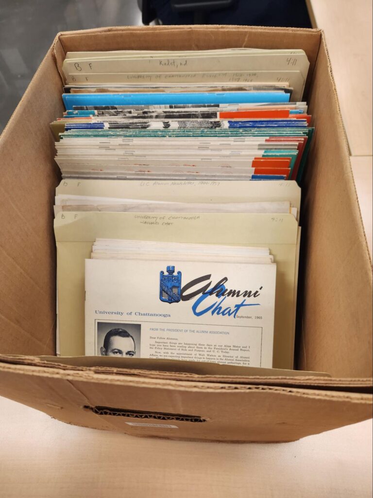 A photograph of the University of Chattanooga Alumni Association newsletters and magazines in their original, unprocessed state.