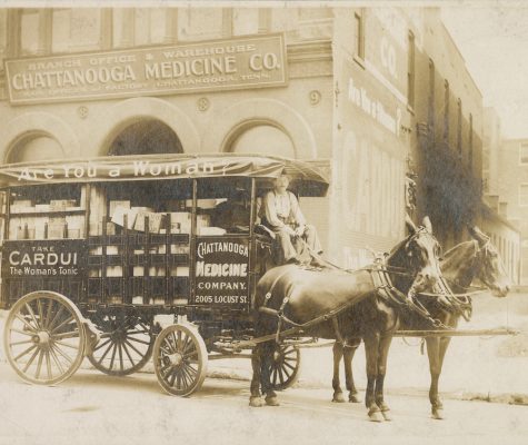 Black-and-white photograph of Chattanooga Medicine Company wagon. The wagon has advertising that reads "Are You a Woman? Take CARDUI The Woman's Tonic CHATTANOOGA MEDICINE COMPANY. 2005 LOCUST ST." Behind the wagon is a printed sign that reads "BRANCH OFFICE & WAREHOUSE CHATTANOOGA MEDICINE CO. MAIN OFFICE AND FACTORY CHATTANOOGA, TENN.