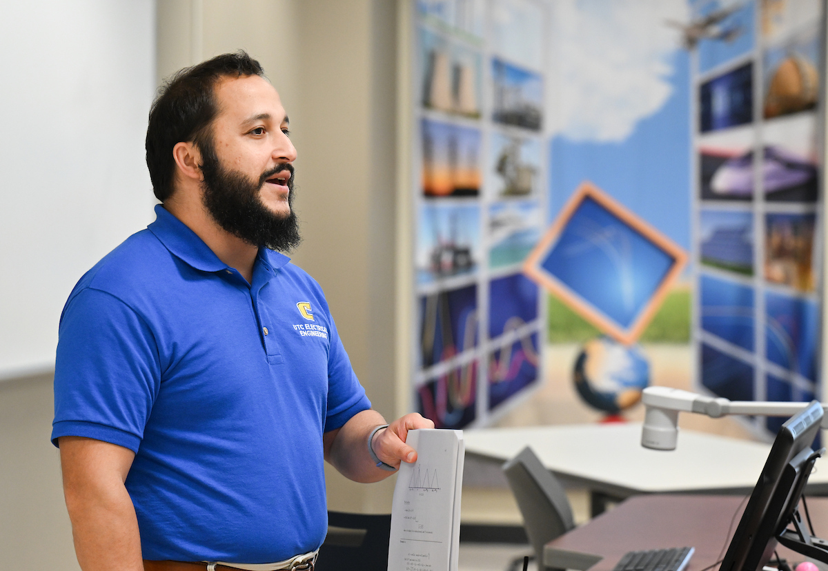 Joshua Tyler stands in front of a greaseboard in his electrical engineering class